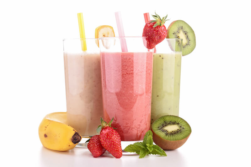 Three different smoothies in glasses beside the ingredients used, suitable to eat after root canal treatment